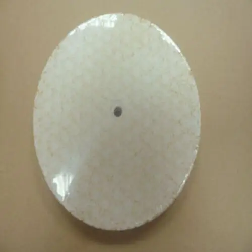 Runde, flache Isolierung von Remeha für einen Feuerungsraum, mit einer glatten Oberfläche und einem zentralen Loch. Farbtönung in Beige mit feinem Muster.
